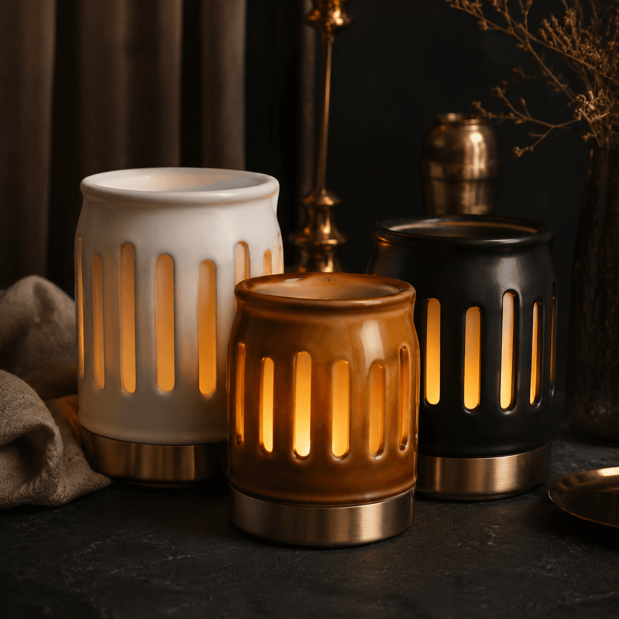 Three glazed ceramic decorative holders in porcelain and amber tones for styling a warm tabletop.
